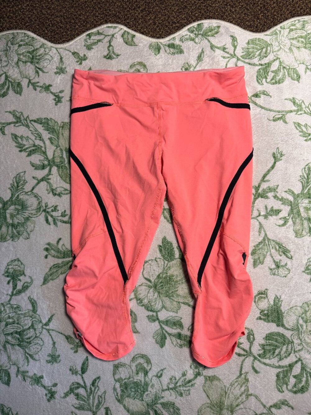 lululemon bright peachy color capri leggings. Black seam details